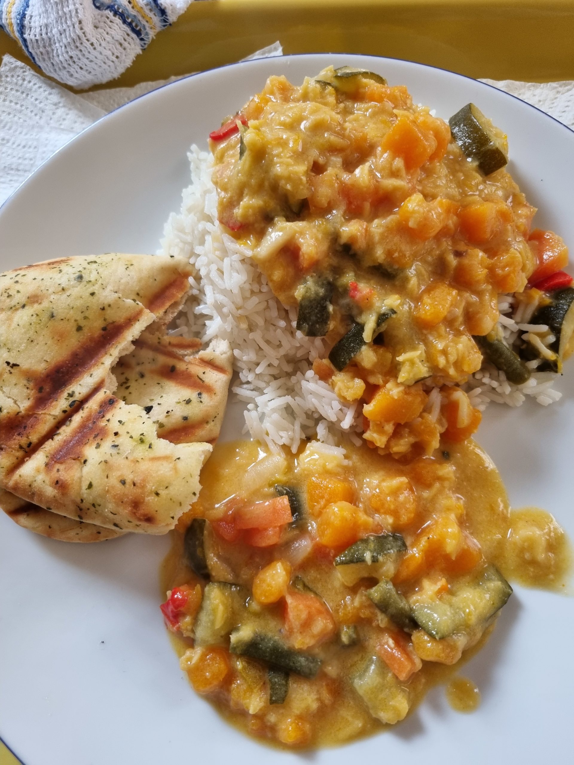 Veg sauce on a plate with rice and flatbread